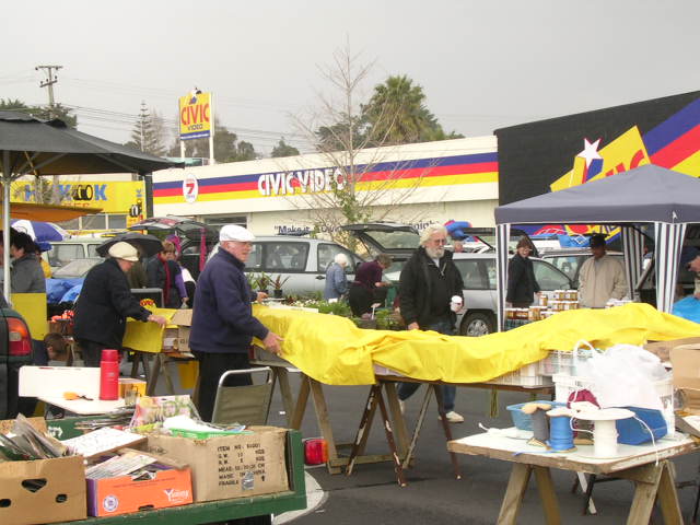 朝市のお店で雨が降ってきたので商品にカバーをかけているところ